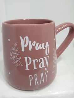 a pink coffee mug that says pray pray