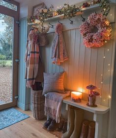 the entryway is decorated with wreaths, lights, and boot boots for winter