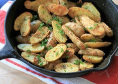 a pan filled with cooked potatoes on top of a red and white towel