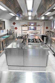 an industrial kitchen with stainless steel appliances and counters, including stove top ovens and sinks