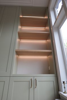 the shelves are built into the side of the wall with lights on each shelf and below them