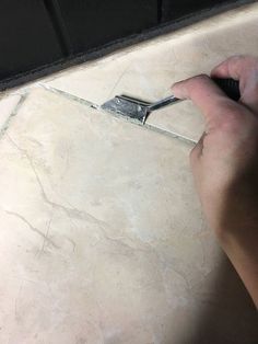 a person using a pair of scissors to cut tile