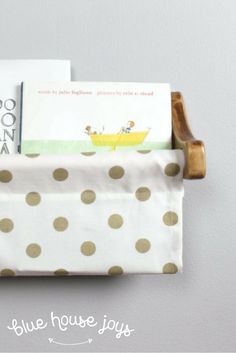 some books are sitting in a holder with polka dots on the bottom and one is open