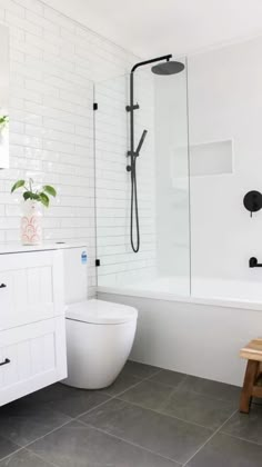 a white bathroom with black accents and tile flooring