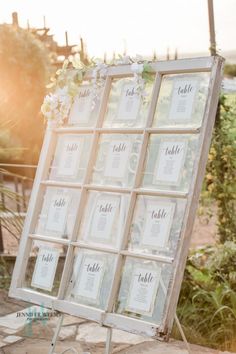 an old window is decorated with flowers and seating cards