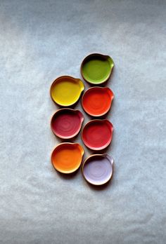 six different colored bowls sitting on top of each other