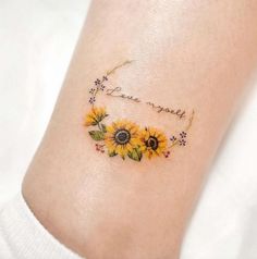 a sunflower tattoo on the ankle that says, love is sweet and has flowers around it