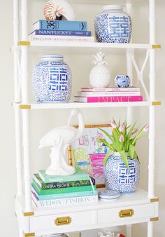 a white shelf filled with books and vases