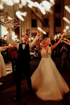 a newly married couple holding sparklers in the air