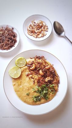 a white plate topped with food next to two bowls filled with different types of food