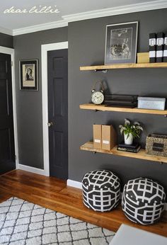 a living room with gray walls and wooden shelves