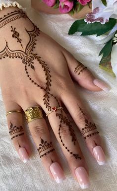 henna tattoo designs on the hand and wrist for women with flowers in the background