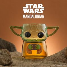 a star wars figurine in a glass cup with the words, mandeloidian on it