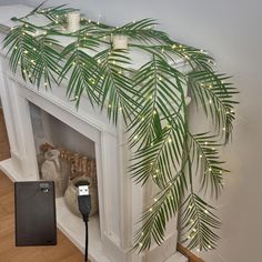 there is a fake palm tree in the corner of this fireplace with lights on it