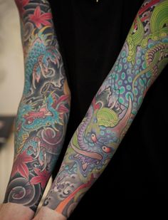 two men with colorful tattoos on their arms and arms, both holding each other's hands