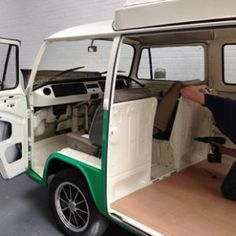 two men sitting in the back of a green and white golf cart with its doors open