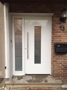 a white front door on a brick building