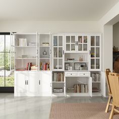 a living room filled with lots of furniture and bookshelves next to a sliding glass door