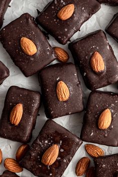 chocolate squares with almonds and sea salt on top, surrounded by pieces of dark chocolate