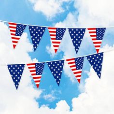 the american flag bunting is flying in the blue sky with white clouds behind it