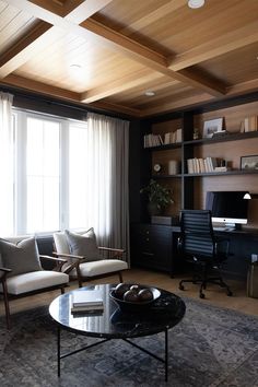 Moody office with a coffee table, chairs, custom built-ins, drapes, white oak beams 
and ceiling shiplap. Shiplap Home Office, Wood Ceiling Office, Moody Office Design, Office With Sofa, Large Home Office Ideas, Dark Wood Office, Dark And Moody Office, Moody Office Inspiration, Masculine Home Office Ideas