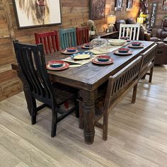 a wooden table with chairs and plates on it