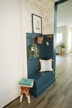 a room with a blue bench and some pictures on the wall next to a white door