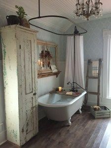 a bathroom with a claw foot tub and chandelier