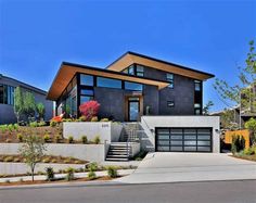 a modern house with two levels and lots of windows