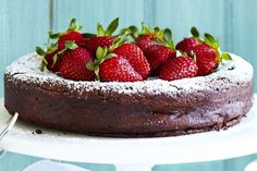 a chocolate cake with fresh strawberries on top