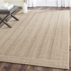 a living room area with a rug, chair and coffee table