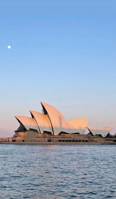 the sydney opera house in australia is lit up by the moon on a clear day