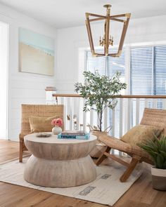 a living room with two chairs, a table and a potted plant in it