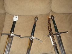 three different types of swords sitting on a couch