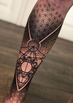 a man's leg with an intricate tattoo on it