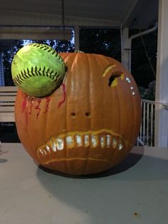 a pumpkin with a baseball on top of it