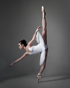 a woman in white is doing a ballet move