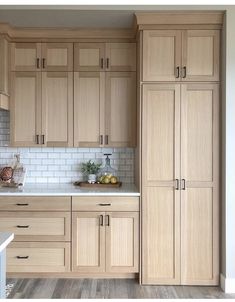 an empty kitchen with wooden cabinets and white tile backsplashes on the walls