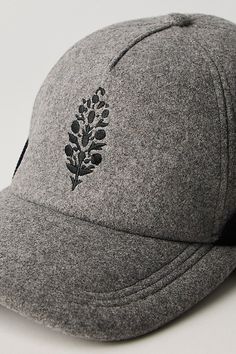 a gray hat with black flowers on it