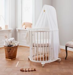 a baby crib in the corner of a room with stuffed animals on the floor