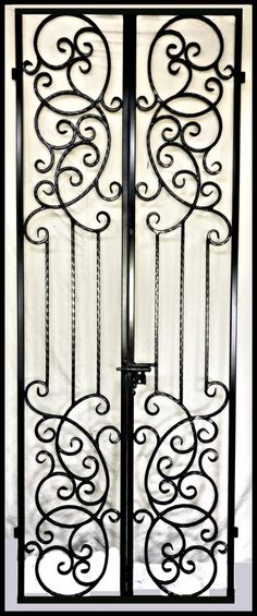 an iron gate with chains hanging from it's sides and a white curtain behind it