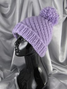 a mannequin head wearing a purple knitted hat