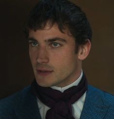 a man in a suit and bow tie looking at the camera with an intense look on his face