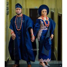 an african couple dressed in traditional clothing and holding hands while standing next to each other