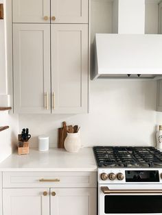 a white stove top oven sitting inside of a kitchen next to cupboards and drawers