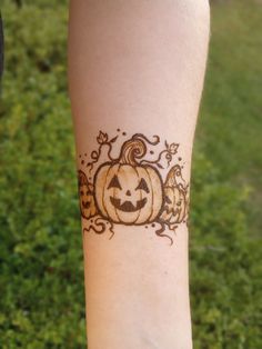 a person with a pumpkin tattoo on their arm