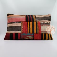 a multicolored patchwork pillow on a white background