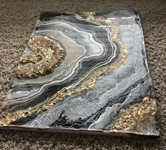 a black and gold marbled tray on the floor in front of a carpeted area