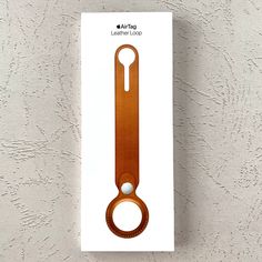 an apple watch strap in the packaging on a white surface with a brown leather band