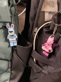 there is a keychain with a lego figure on it next to a backpack